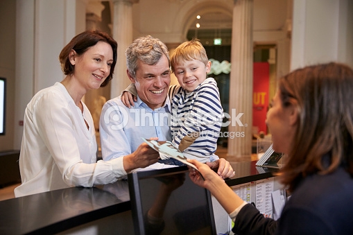 Family Buying Entry Tickets To Museum From Reception